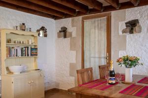 Rose Barn في Cersay: غرفة طعام مع طاولة مع زجاجة من النبيذ