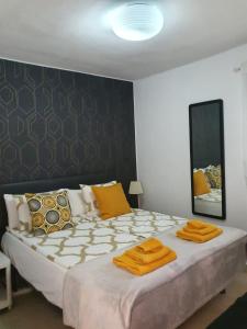 sypialnia z dużym łóżkiem z pomarańczowymi poduszkami w obiekcie Mint Apartment w mieście San Bartolomé