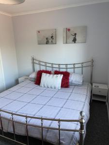 una camera da letto con un letto con cuscini rossi di Palmbeach Place a Kent