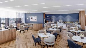 Staybridge Suites - Al Khobar City, an IHG Hotel في الخبر: مطعم بجدران زرقاء وطاولات وكراسي