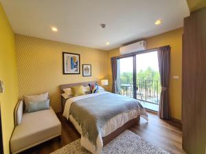 1 dormitorio con 1 cama, 1 silla y 1 ventana en Huahin mountain view room near the beach, en Hua Hin