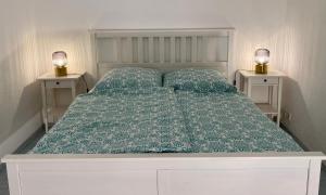 ein Bett mit einer grünen Bettdecke und zwei Nachttischen in der Unterkunft Casa Wimmer in Allendorf an der Lumda