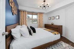 a bedroom with a large white bed and a window at Chic Retreat, Modern, Pool, Hot Tub, Gym in Invermere +17 photos