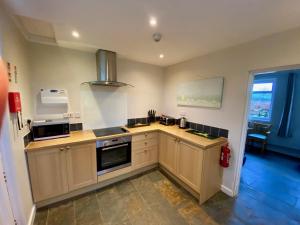 Una cocina con gabinetes de madera y un horno de estufa. en Exmouth Country Lodge and Cottage, en Exmouth 13 fotos más