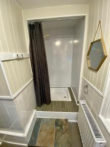 baño pequeño con ducha y espejo en Exmouth Country Lodge and Cottage, en Exmouth