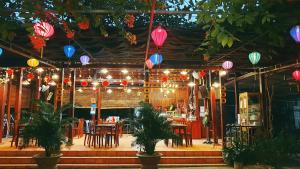 un restaurante con mesas, sillas y faroles coloridos en Thuy Tien Ecolodge en Cat Tien