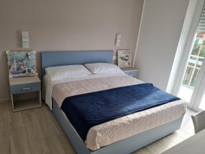 1 dormitorio con 1 cama con cabecero azul en B&B Rayl en Formia