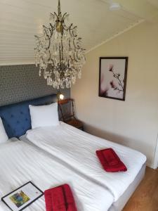 ein Schlafzimmer mit einem weißen Bett mit roten Handtüchern darauf in der Unterkunft Karlsberg Gård B&B in Tvååker