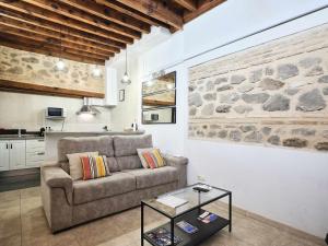 a living room with a couch and a stone wall at La Casa del Lirón by Toledo AP in Toledo