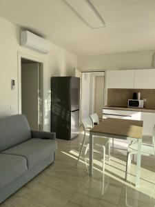 a kitchen and living room with a table and a couch at Agua Apartment with beach included in Lido di Jesolo