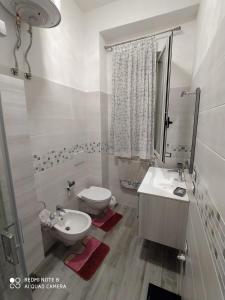 a white bathroom with a sink and a toilet at Luxury House in Cirò Marina