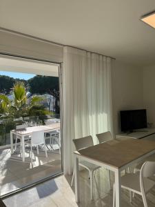 a dining room with a table and chairs and a balcony at Agua Apartment with beach included in Lido di Jesolo