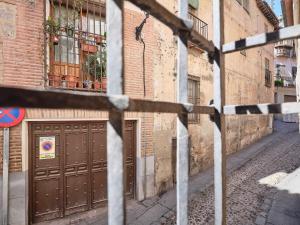 un callejón con dos puertas marrones de garaje en un edificio en La Casa del Lirón by Toledo AP, en Toledo