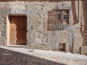 un edificio de ladrillo con puerta de madera y ventana en La Casa del Lirón by Toledo AP, en Toledo