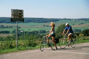 a man and a woman riding bikes on a road at Hotel Inkelshoes in Epen