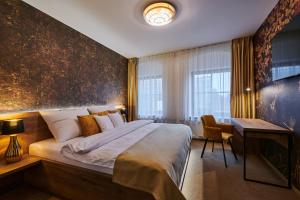 奥洛穆茨Hotel Alfréd a Hermína的一间带大床和书桌的卧室