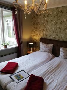 Un dormitorio con una cama con un libro. en Karlsberg Gård B&B, en Tvååker