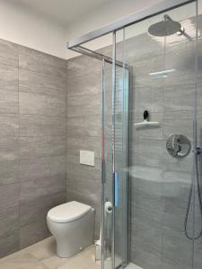 a bathroom with a toilet and a glass shower at Agua Apartment with beach included in Lido di Jesolo +9 photos