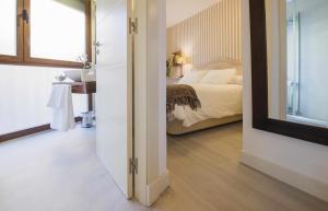 a room with a bedroom with a bed and a mirror at Apartamentos Abadía by Toledo AP in Toledo