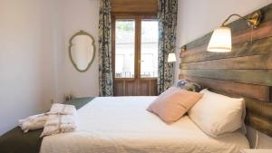 una camera da letto con un letto grande con testiera in legno di Apartamento Pasaje del Barco by Toledo AP a Toledo