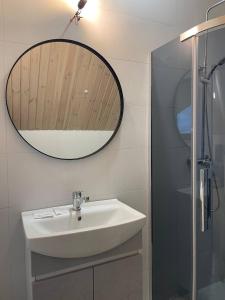 La salle de bains est pourvue d'un lavabo et d'un miroir. dans l'établissement M.A.K.home, à Vyshka