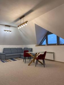 uma sala de estar com um sofá, uma mesa e cadeiras em M.A.K.home em Vyshka
