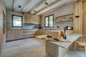 una cocina con armarios de madera y una mesa con un plato de comida en Chalet La Mésange Cendrée, en Morzine