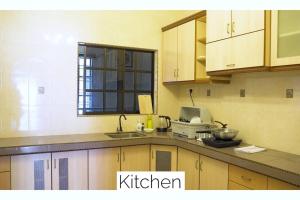 a kitchen with a sink and a counter top at The Pigeon Alor Akar Guest House in Kuantan