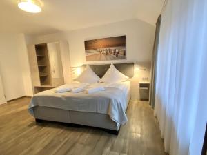 Schlafzimmer mit einem Bett mit Wandgemälde in der Unterkunft Hotel Kranenborgh Steinhude am Meer in Steinhude