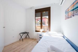 Un dormitorio blanco con una cama y una ventana. en El Mirador de la Catedral by Toledo AP, en Toledo