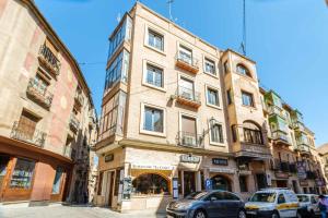 a tall building with cars parked in front of it at El Mirador de la Catedral by Toledo AP in Toledo