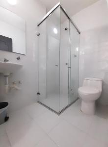 a white bathroom with a shower and a toilet at Hotel Centauros del Llano in Villavicencio