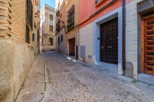 an empty street in an alley in an old town at Toledo AP Alojamiento Turísticos in Toledo
