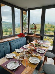 uma mesa longa com pratos de comida numa sala com janelas em M.A.K.home em Vyshka