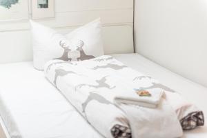 a white bedroom with a bed with a wolf comforter at Zinsers Bergliebe in Inzell