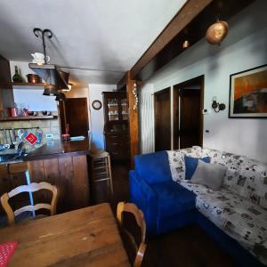 un soggiorno con divano blu e tavolo di Casa Orsola - Your Mountain Holiday a Premana