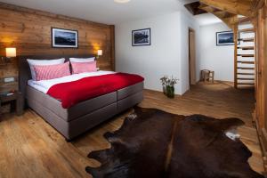 Un dormitorio con una cama grande con una manta roja. en Watzmann-Appartement, en Ramsau