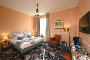 a hotel room with a bed and a chair at Grand Hôtel Henri - Teritoria in LʼIsle-sur-la-Sorgue