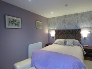 a hotel room with a bed and a lamp at The Bay Horse Hotel And Restaurant in Ulverston