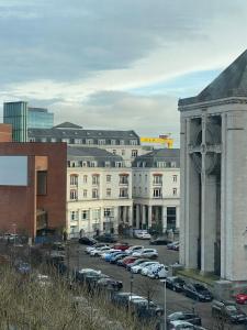 a parking lot with cars parked in front of a building at Quarter by the Warren Collection in Belfast