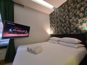 Schlafzimmer mit einem Bett und einem Flachbild-TV an der Wand in der Unterkunft Urban Studio in city center in Belgrad