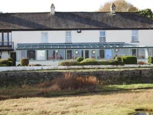 a large white house with a yard in front of it at The Bay Horse Hotel And Restaurant in Ulverston