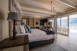 een slaapkamer met een bed en een tafel met een lamp bij 52 on Fish Hoek in Kaapstad