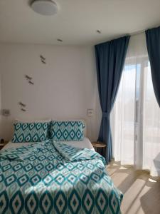 ein Schlafzimmer mit einem Bett und einem großen Fenster in der Unterkunft Villa Mimi in Dobreć