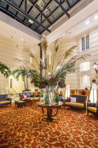a lobby with couches and a table with flowers at Hotel Polonia Palace in Warsaw