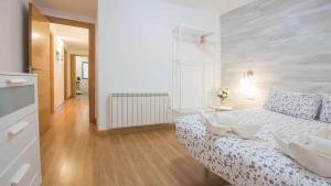Dormitorio blanco con cama con almohadas blancas en La casa de los Becquer by Toledo AP, en Toledo