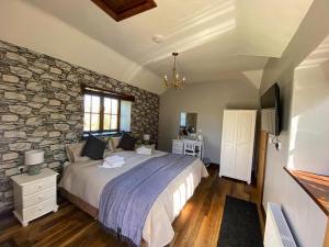 The Mary Tavy Inn في تافيستوك: غرفة نوم بسرير وجدار حجري