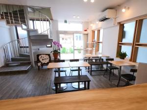 a room with tables and chairs and a staircase at Ishigakijima Hotel Olive in Ishigaki Island