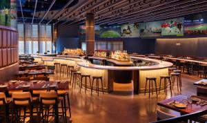 um restaurante com um bar e mesas e cadeiras em Omni Boston Hotel at the Seaport em Boston