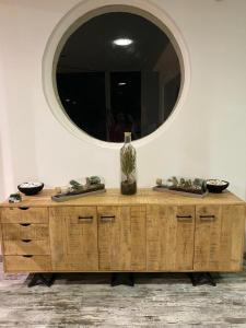 een houten dressoir met een spiegel erop bij Mariana Plage in La Marana